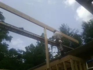 Carpenter setting a ridge beam over a new addition frame — Ice Dam Removal by Roofing Brothers in Seven Valleys