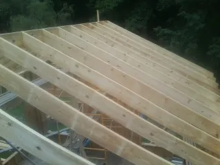 New roof rafters set over an addition before sheathing in Seven Valleys