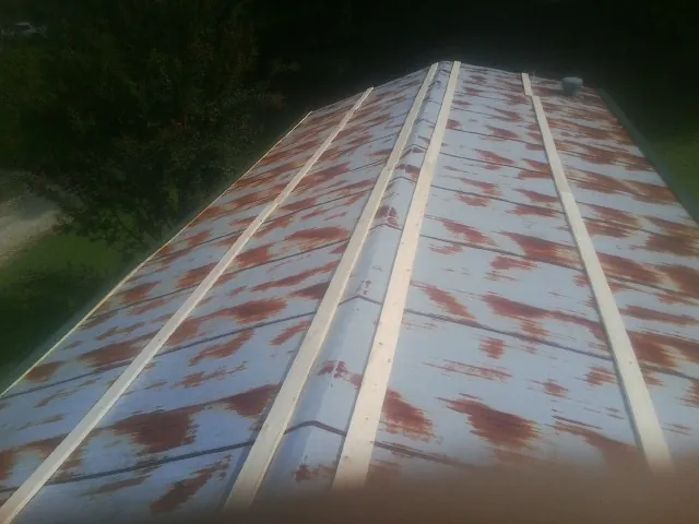 Rusted metal roof panels with new wood purlins before replacement — Storm Damage Roof Repair in Seven Valleys by Roofing Brothers
