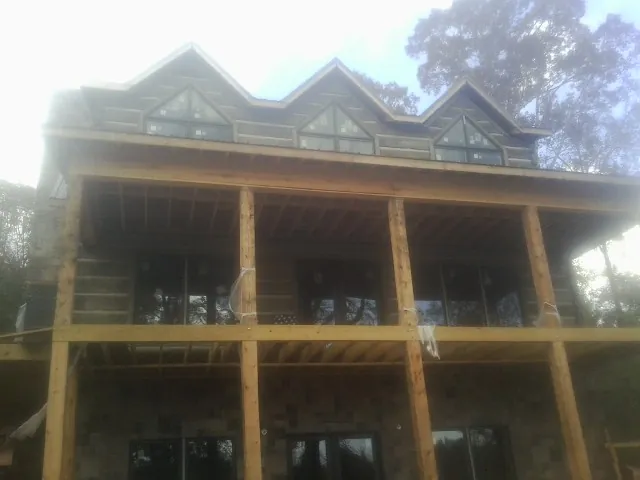 Dormers and porch framing on a large log home under construction — Roof Coating work by our crew in Seven Valleys