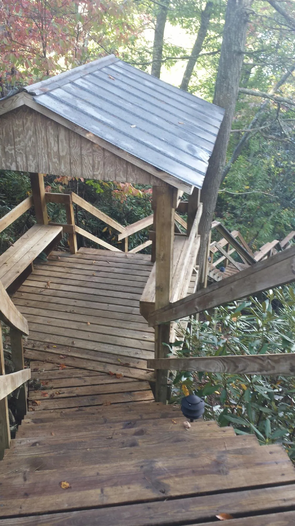 Metal roofed shelter over wooden steps on a wooded walkway — Skylight Repair & Installation work by our crew in Seven Valleys