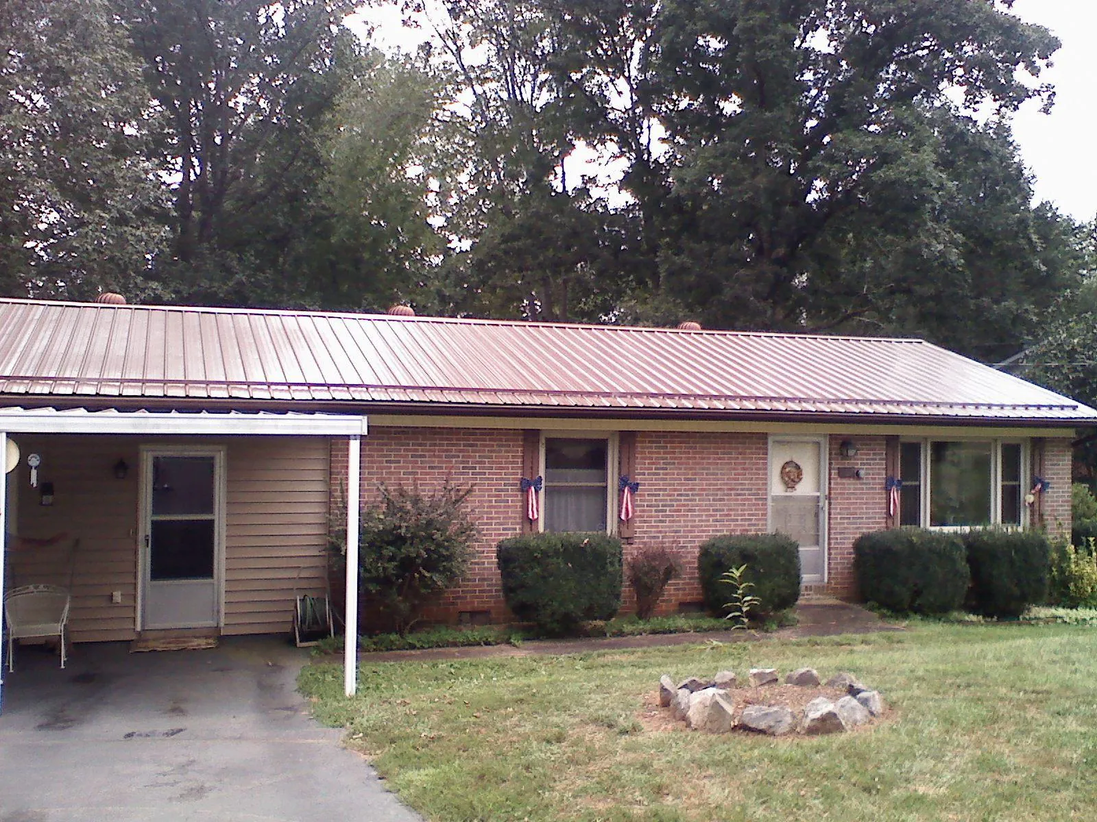 Bronze metal roof and carport on a brick ranch home — Roof Repair work by our crew in Seven Valleys